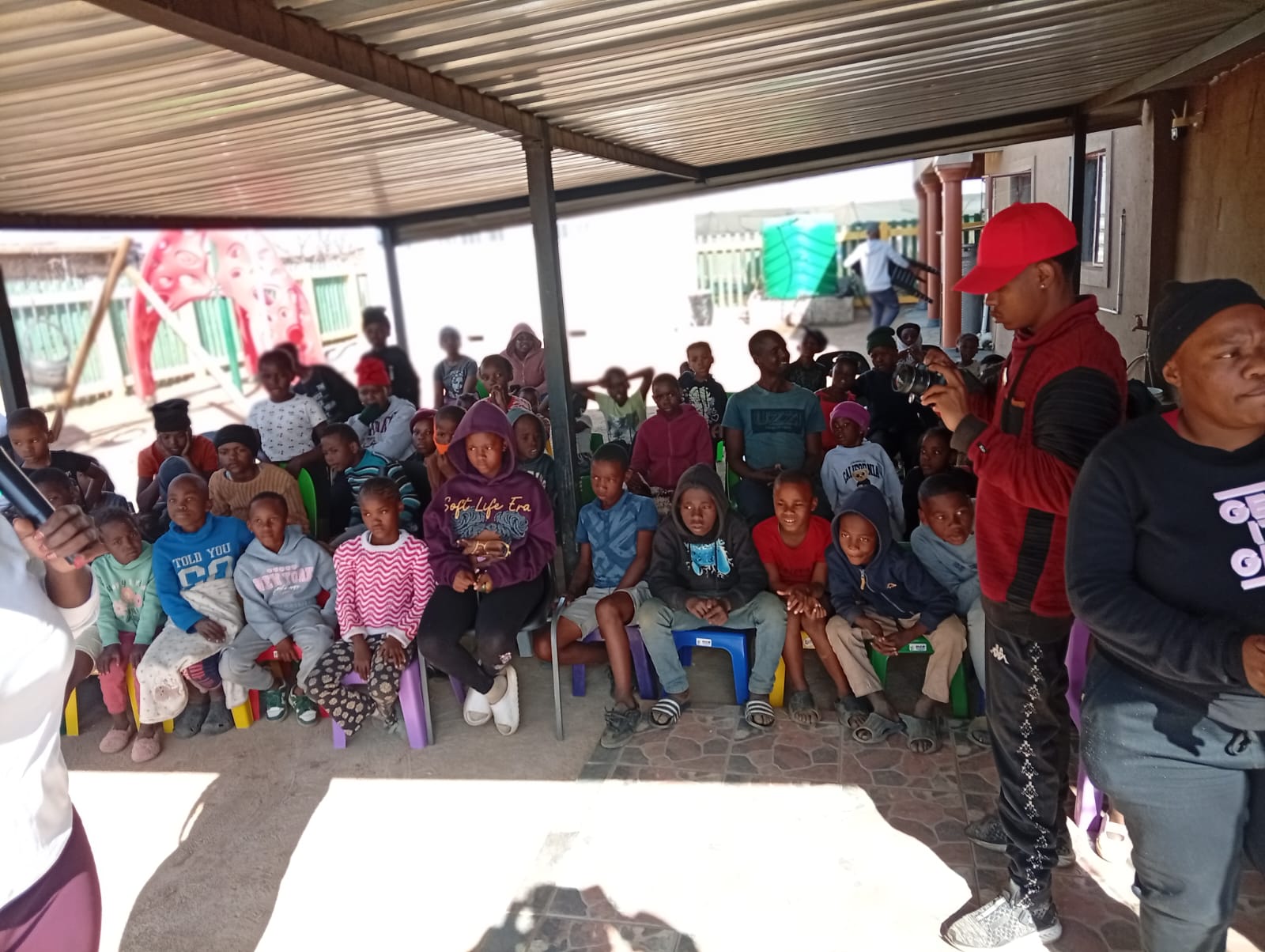 Children and adults gathered with community members at the Bokamoso centre