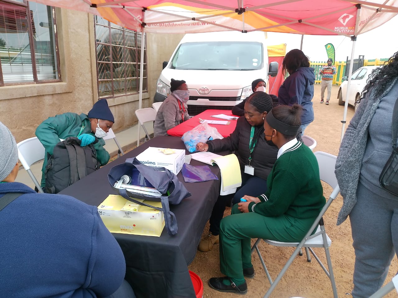 Community members and outreach workers at a health information table